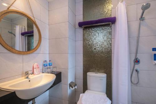 a bathroom with a sink and a toilet and a mirror at Rumaruma Farvet Residence @ Ambon in Ambon