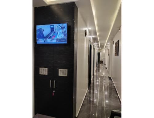 a hallway with a black door with a tv on it at Royal Galaxy, Narnaul in Nārnaul