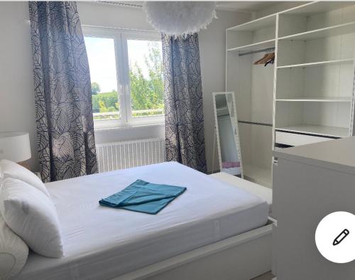 um quarto com uma cama com uma toalha azul em Maison au calme avec piscine près de Truchtersheim, à 15 minutes de Strasbourg em Durningen