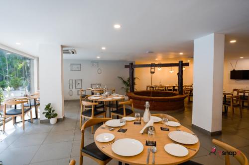 a restaurant with wooden tables and chairs and a fountain at Magnum Resorts- Near Candolim Beach, Goa in Candolim