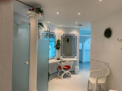 a bathroom with a sink and a mirror and a chair at Sunside Ferien Wellness Oase Hotel Apartment's Schwarzwald am Schluchsee in Schluchsee