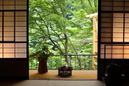 a room with a window with a plant on a porch at Fukeikan 風景館 in Takayama