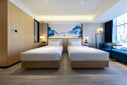 two beds in a hotel room with at Ausotel by Argyle Baiyun International Airport Renhe Metro Exit B in Guangzhou