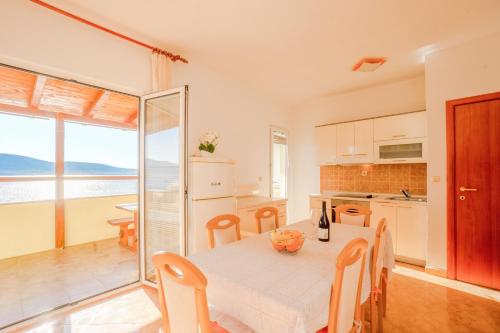 a kitchen and dining room with a table and chairs at Marija at the beach in Zubovići