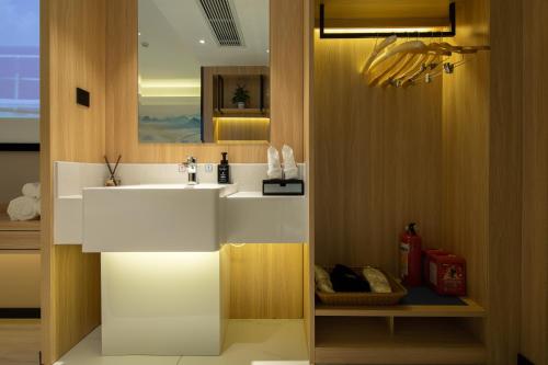 uma casa de banho com um lavatório e um espelho em Ausotel by Argyle Baiyun International Airport Renhe Metro Exit B em Guangzhou