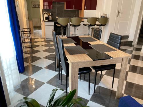 une salle à manger avec une table et des chaises et une cuisine dans l'établissement Calme et spacieux près du Loing et du centre, à Moret-sur-Loing