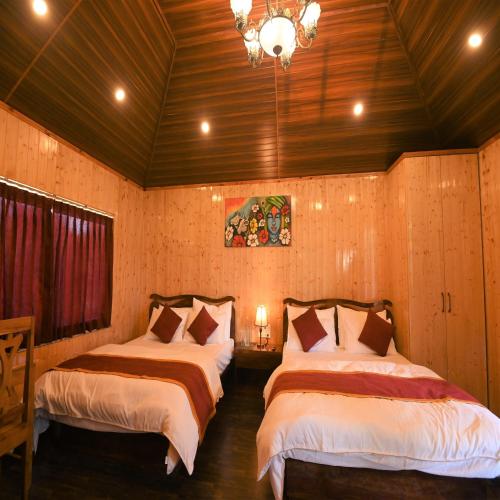 a bedroom with two beds and a chandelier at Amaira Resort & Farms - Mirik, West Bengal in Mirik