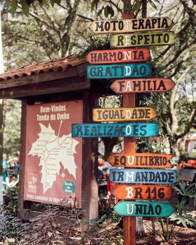 a bunch of signs on a pole in a field at Cabana na Serra Gaúcha! in Picada Cafe