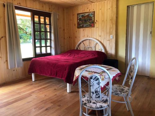 a bedroom with a bed with a table and two chairs at Cabana na Serra Gaúcha! in Picada Cafe