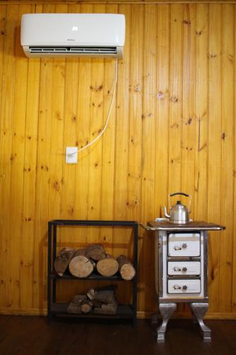 a kitchen with a stove and a shelf with logs at Cabana na Serra Gaúcha! in Picada Cafe