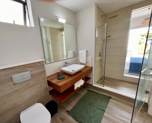 a bathroom with a sink and a shower at Tropical beachfront apartment in Belle Mare