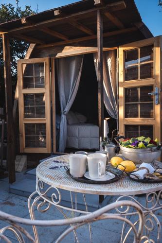 una mesa con tazas de café y un bol de fruta en Dormire in una Botte, en Angri