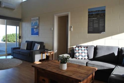 Una sala de estar con un sofá y una mesa de café. en Hideaway Tom’s on Mundoo Channel - Waterfront, en Hindmarsh Island