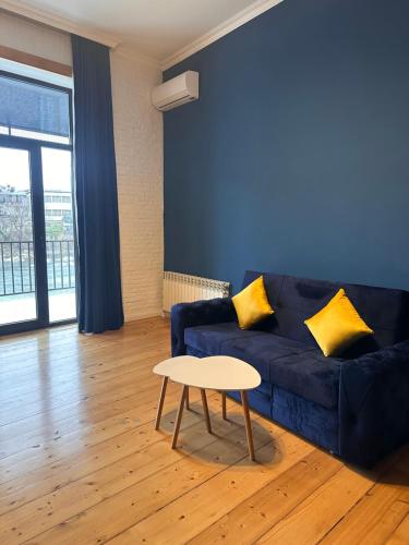a living room with a blue couch and a table at Apartment Riverside in Kutaisi