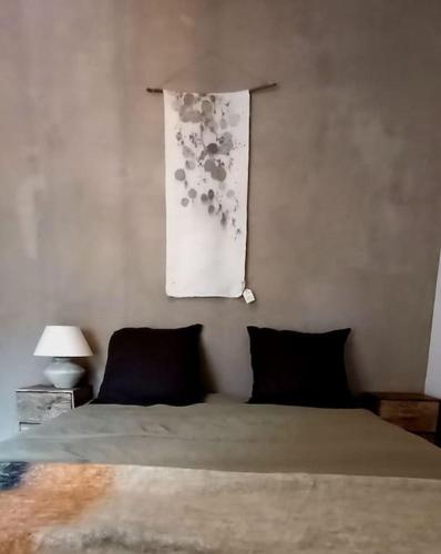 une chambre avec un lit et un tableau au mur dans l'établissement Gîte au cœur des châteaux de la Loire, à Cellettes