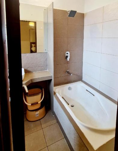 a bathroom with a bath tub and a sink at SUN N SEA Resort in Diveagar