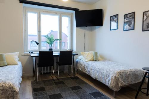 a bedroom with a desk and a bed and a window at Studio apartment in central Turku in Turku