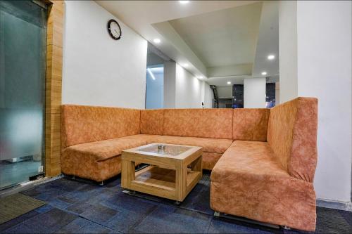 a couch and a table in a room at FabExpress Galaxy Stay - Nr Morya Hospital in Pune
