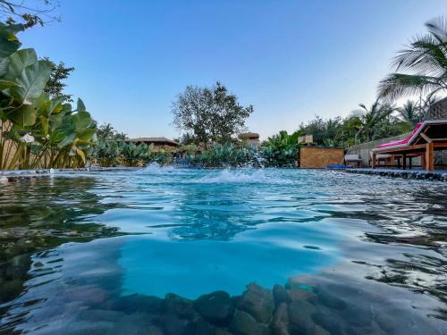 uma piscina com água azul num resort em One At Goa em Canacona
