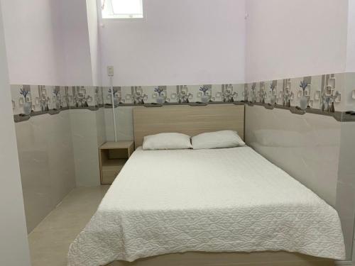 1 dormitorio con cama blanca y ventana en gau homestay en Tuy Hoa