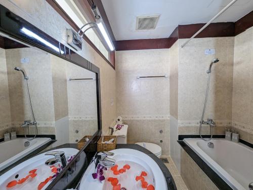 ein Badezimmer mit einer Badewanne, einem Waschbecken, einer Badewanne und einem WC in der Unterkunft Đông Kinh Hotel in Ho-Chi-Minh-Stadt