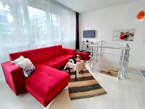 ein Wohnzimmer mit einem roten Sofa und einer Treppe in der Unterkunft Sere in Antalya