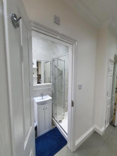a white bathroom with a sink and a mirror at Cosy Entire Home Kingscross Central London in London