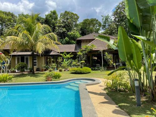 Villa con piscina frente a una casa en Lui Farm Villa - Private Villa for Staycation & Retreat, en Hulu Langat