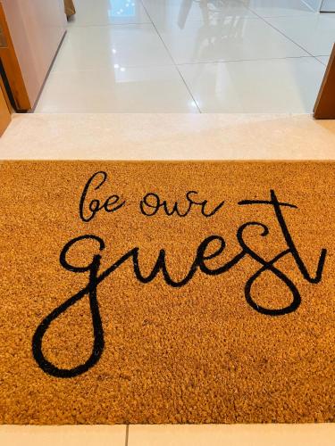 a sign that says be our guest on a rug at Ocean Heights - Spacious 1 Bedroom Apartment with Sea View, Gym & Free Parking in Dubai