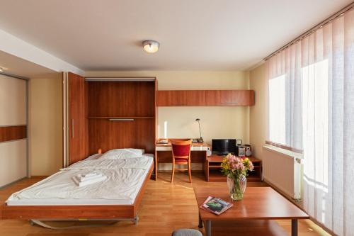 Schlafzimmer mit einem Bett, einem Schreibtisch und einem Tisch in der Unterkunft Urpí­n City Residence in Banská Bystrica