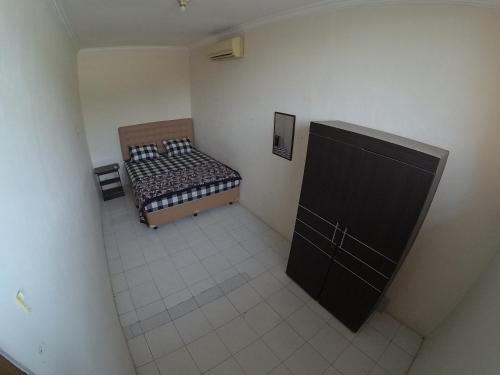 einen Blick über ein Schlafzimmer mit einem Bett und einer Tafel in der Unterkunft Omah Nandan Homestay Jogja in Kejayan