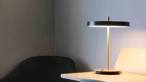 a lamp sitting on a table next to a chair at Medlefors Hotell & Konferens in Skellefteå