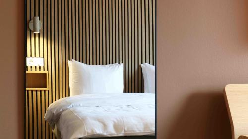 a bedroom with a bed with a striped wall at Medlefors Hotell & Konferens in Skellefteå