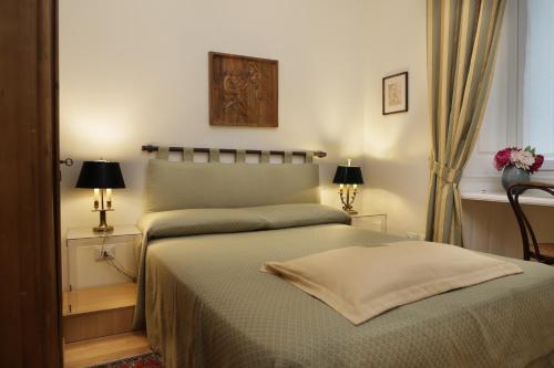 a bedroom with a bed and two lamps and a window at Residenza Le 6 A in Trieste