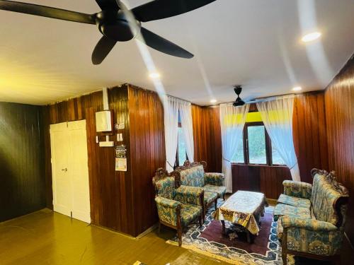 a living room with two chairs and a ceiling fan at NAZIRIN HOMESTAY D’VILLAGE MUAR BATU PAHAT in Semerah