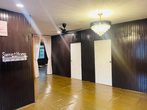 a room with a chandelier and a hallway with a hard wood floor at NAZIRIN HOMESTAY D’VILLAGE MUAR BATU PAHAT in Semerah
