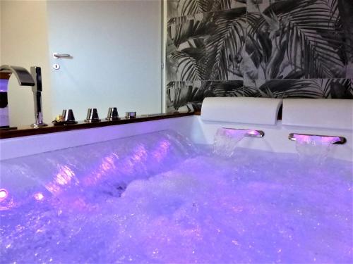 Habitación con bañera llena de agua púrpura. en Casa Maia, en Casalabate