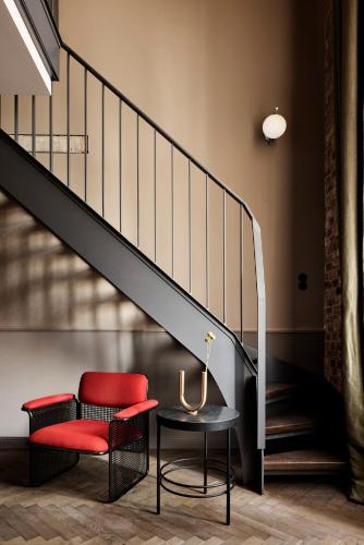 a red chair and a table next to a staircase at Telegraphenamt in Berlin