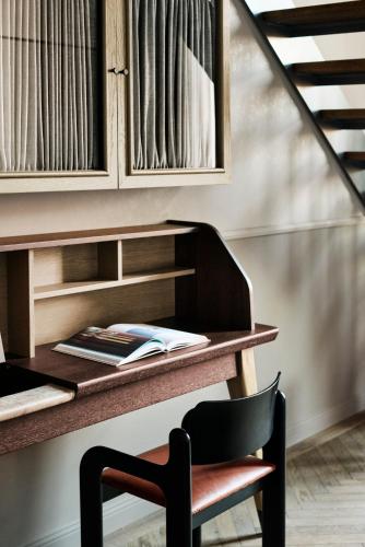 a desk with a chair next to a staircase at Telegraphenamt in Berlin