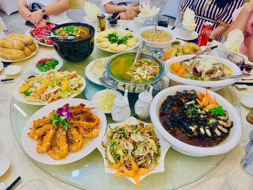 a table with many plates of food on it at Viktor Legends Hotel in Móng Cái