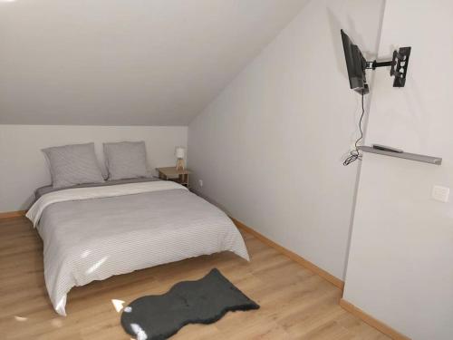 une chambre avec un lit et une télévision au mur dans l'établissement Famille House 202, à Chalon-sur-Saône