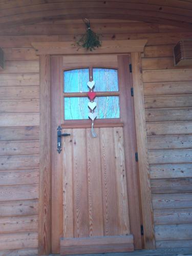 a door of a wooden cabin with a cross on it at Camping des Saules in Jurbise