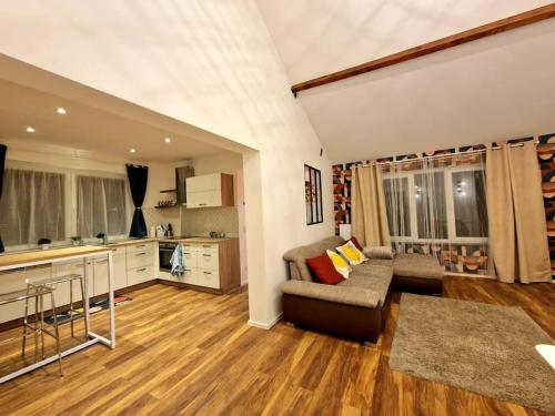 Il comprend un salon avec un canapé et une cuisine. dans l'établissement Ultimate escape from Luxembourg, à Arlon