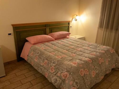 ein Bett mit zwei rosa Kissen in einem Schlafzimmer in der Unterkunft ConcaverdeClub in Sogliano al Rubicone