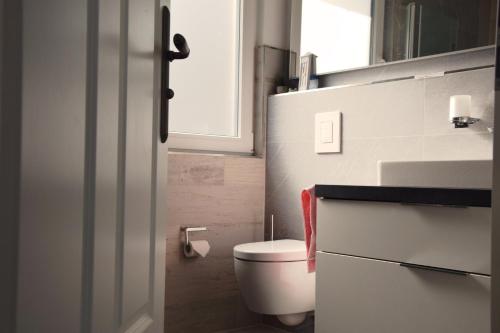 a bathroom with a toilet and a sink and a window at Ferienhaus Reiherweg in Bedekaspel