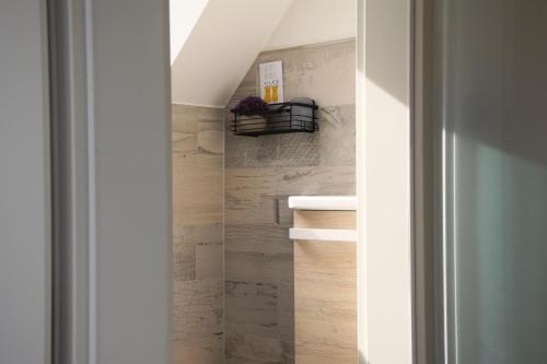 a bathroom with a sink and a wooden wall at Ferienhaus Reiherweg in Bedekaspel