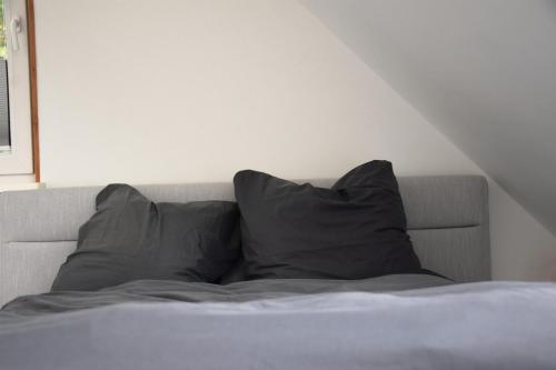 a bed with two pillows on top of it at Ferienhaus Reiherweg in Bedekaspel