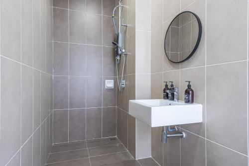 y baño con ducha, lavabo y espejo. en 5Bedroom Villa @ Seremban 20pax Netflix Projector Pool, en Seremban