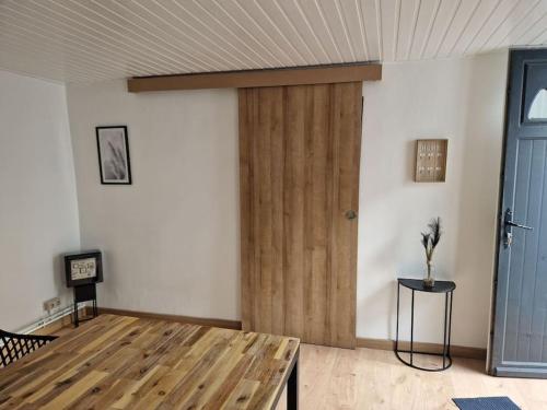 um quarto com uma porta de madeira e uma mesa em Petite maison chaleureuse avec parking em Leuze-en-Hainaut