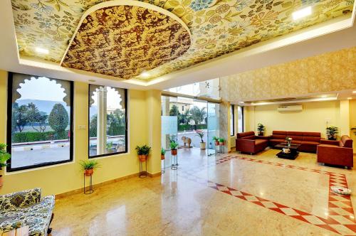 a lobby with a couch and tables and windows at Padmini Bagh Resort by Inventree, Udaipur in Udaipur